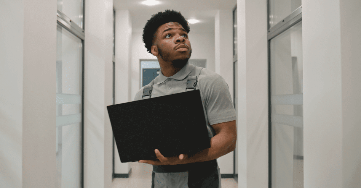 Ciena employee with a laptop, looking around in a hallway