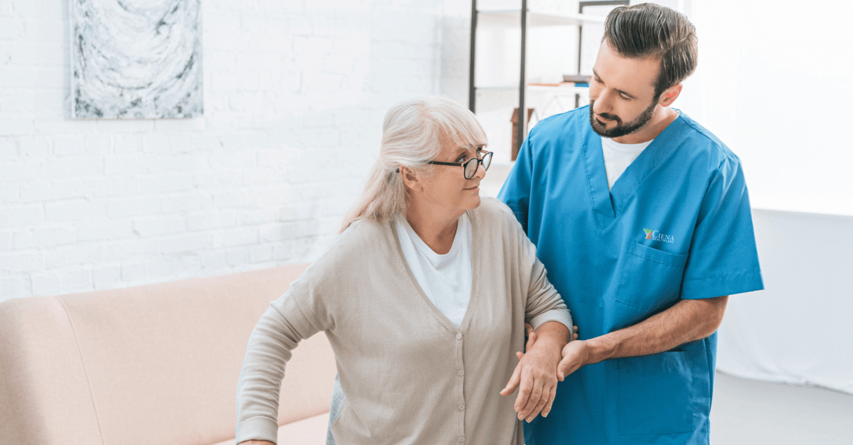 Nurse supporting patient by the arm while walking