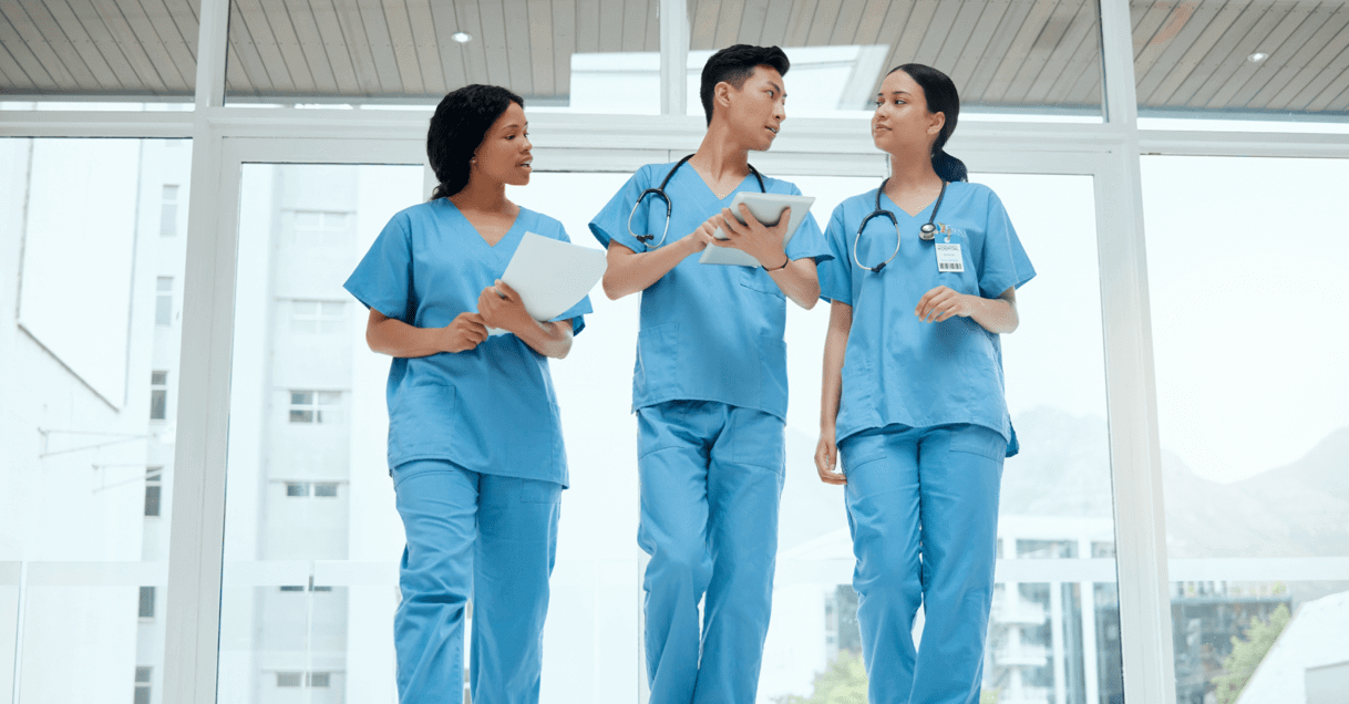 Three nurses in scrubs, walking together