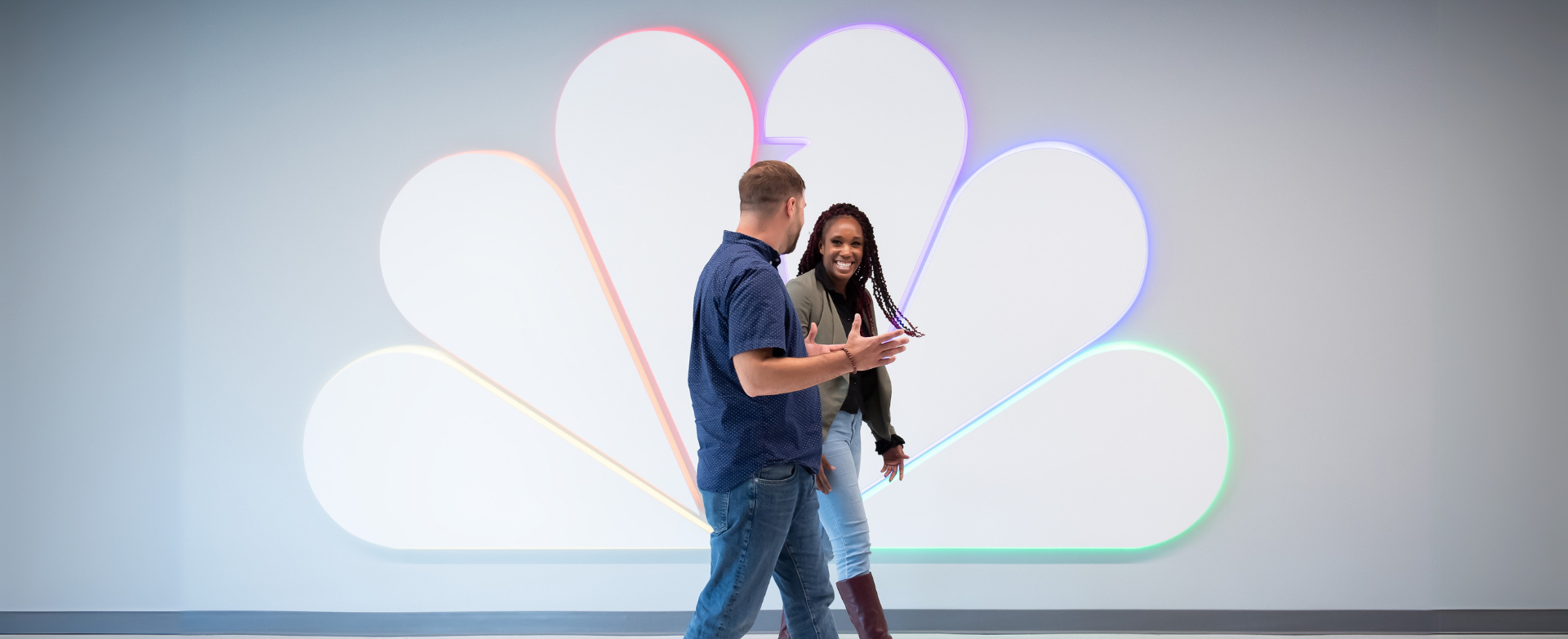 Male and female employee walking down steps while laughing with each other