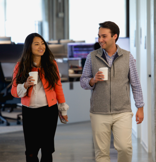 Employees walking with coffees in hand