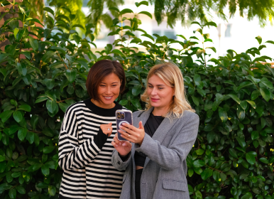 Two employees looking at a phone together