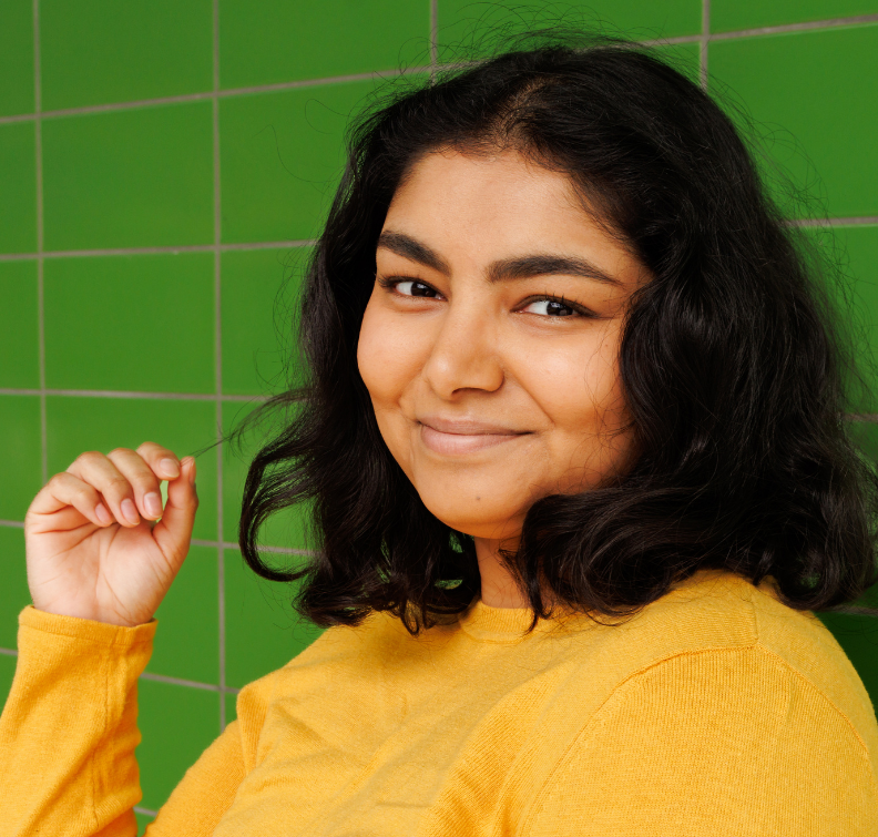 Student in yellow sweater smiling