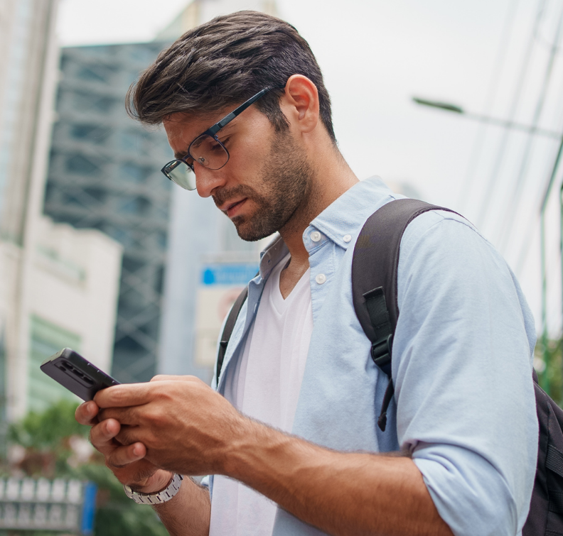 Student with backpack looking at phone