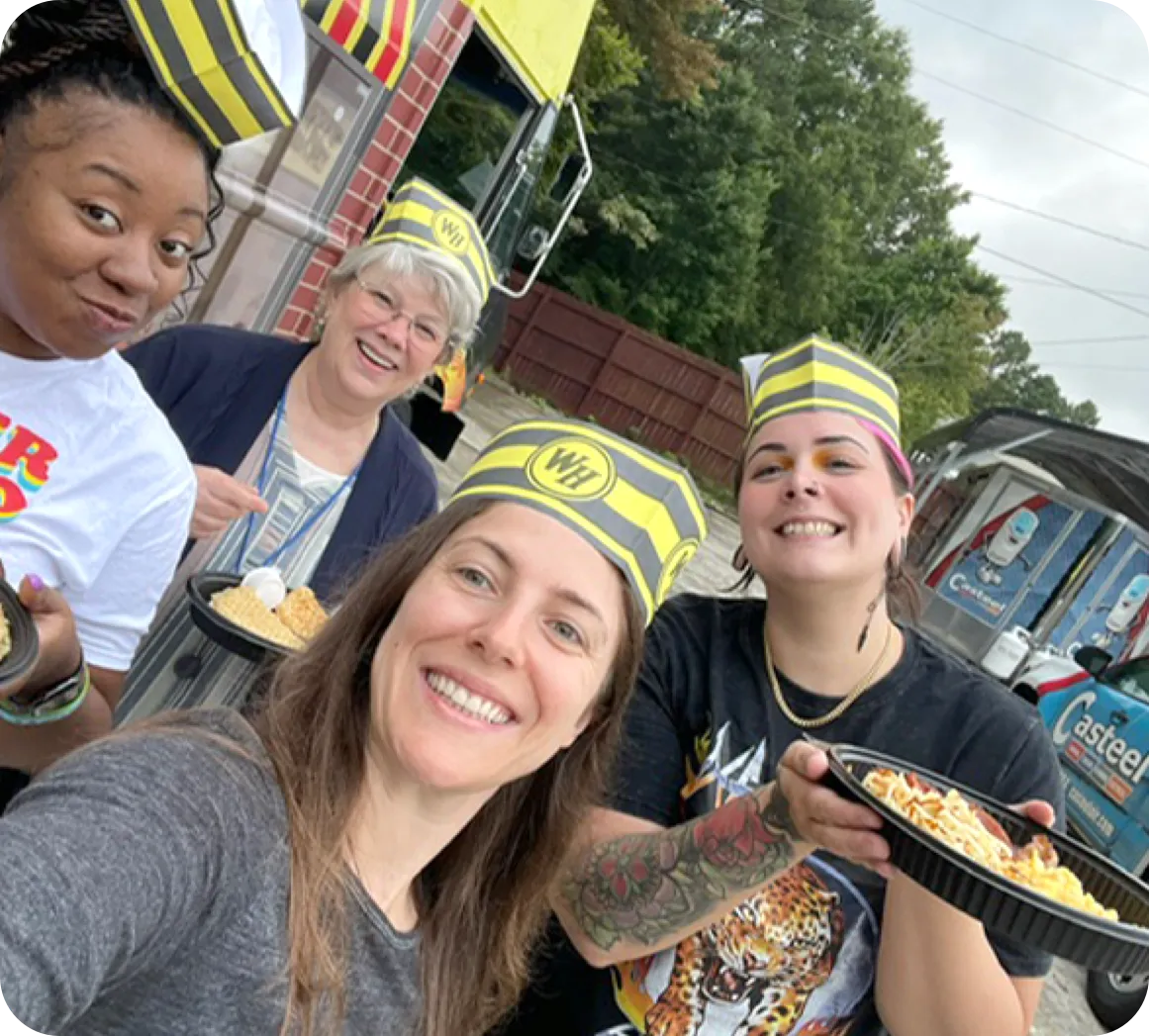 Employees smiling for the camera holding a trophy belt