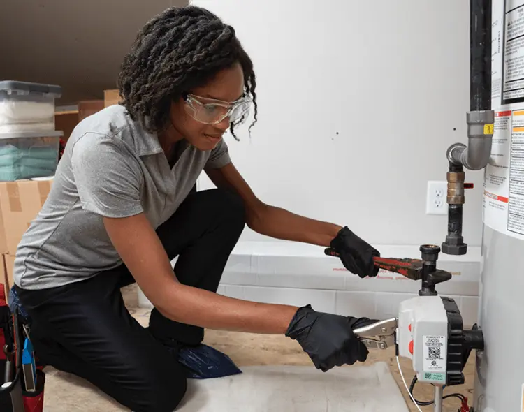 Technician installing a gas hot water heater.