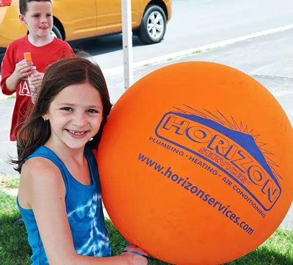 Child with an orange Horizon Services balloon