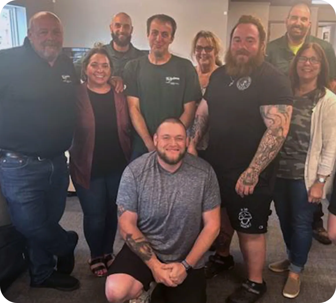 Employees smiling for the camera holding a trophy belt