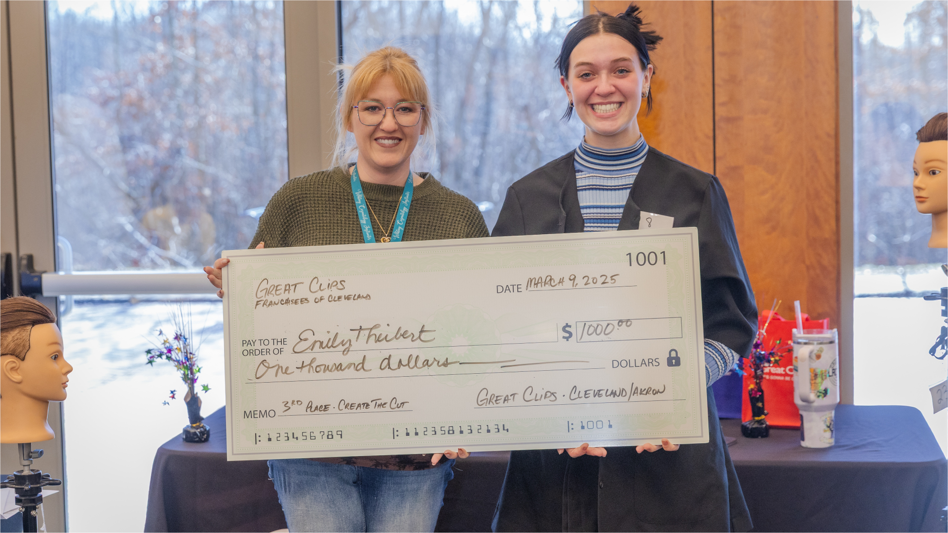Smiling student competition winners with giant check