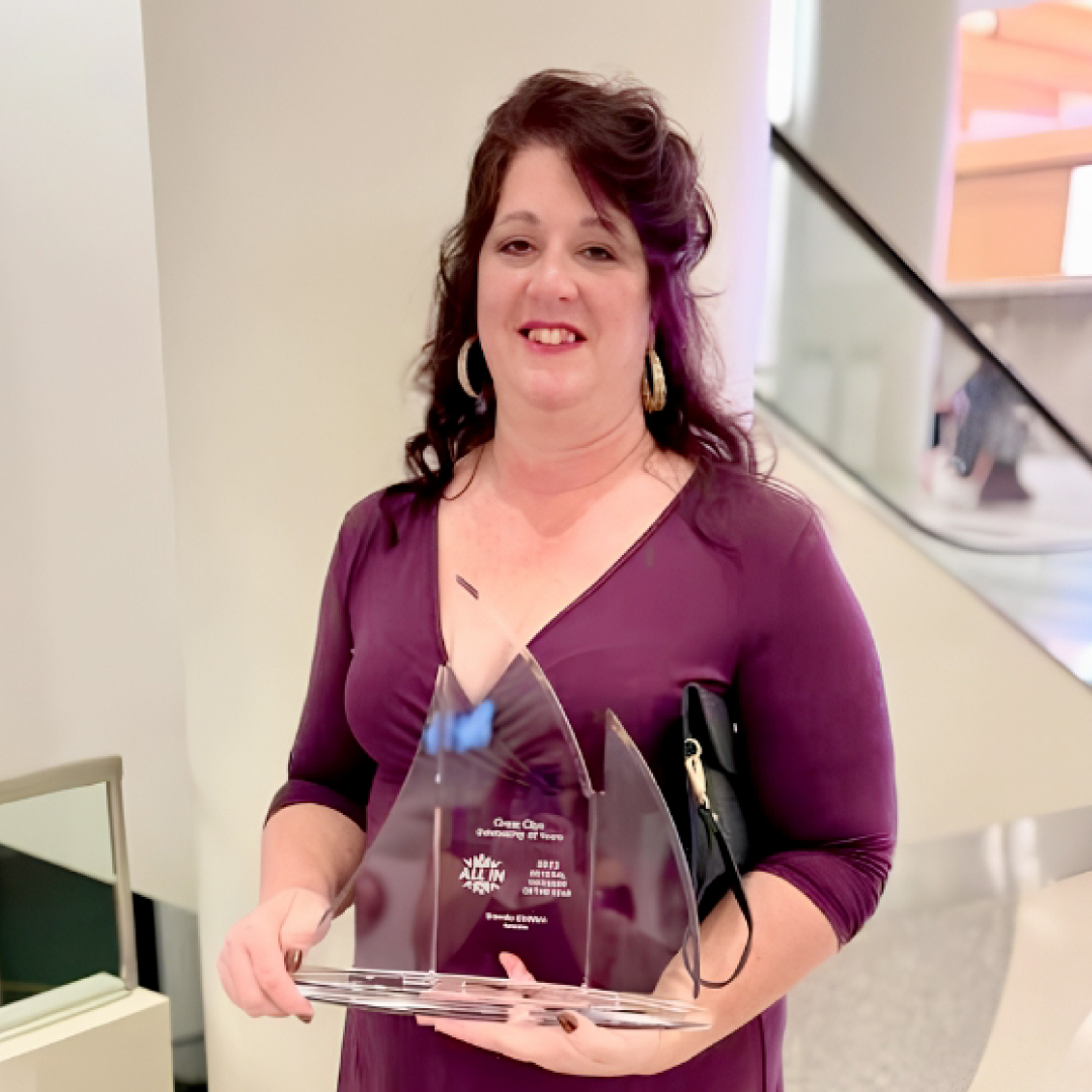 Brenda smiles, holding her award for GM of the Year