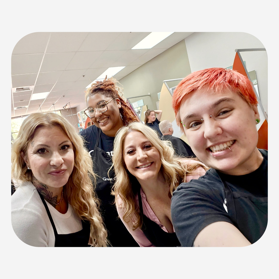 Trinity smiles and takes a selfie with team members in her salon
