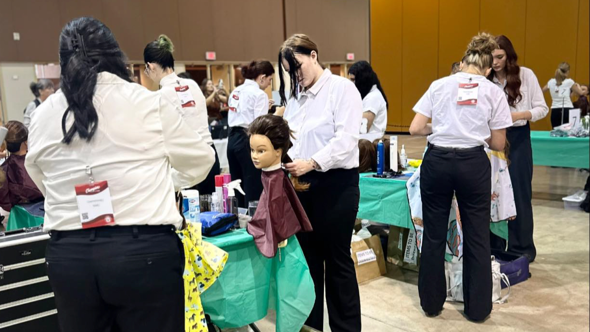 Student competitors and judges stand near mannequins mid-Competition at SkillsUSA