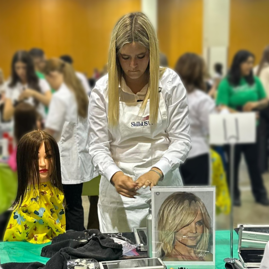 Student works on mannequin with inspiration photo in the foreground at SkillsUSA