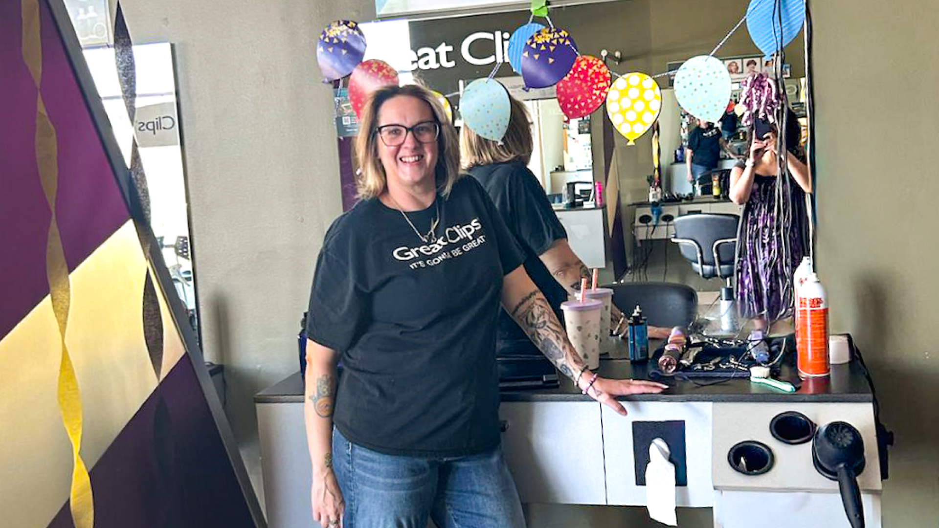 Catie smiling in front of her decorated salon station