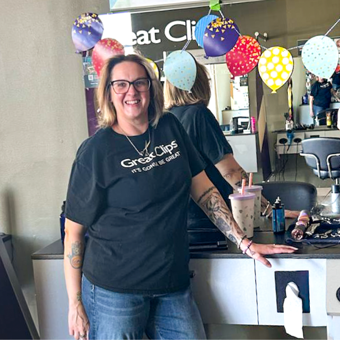 Catie smiling in front of her decorated salon station