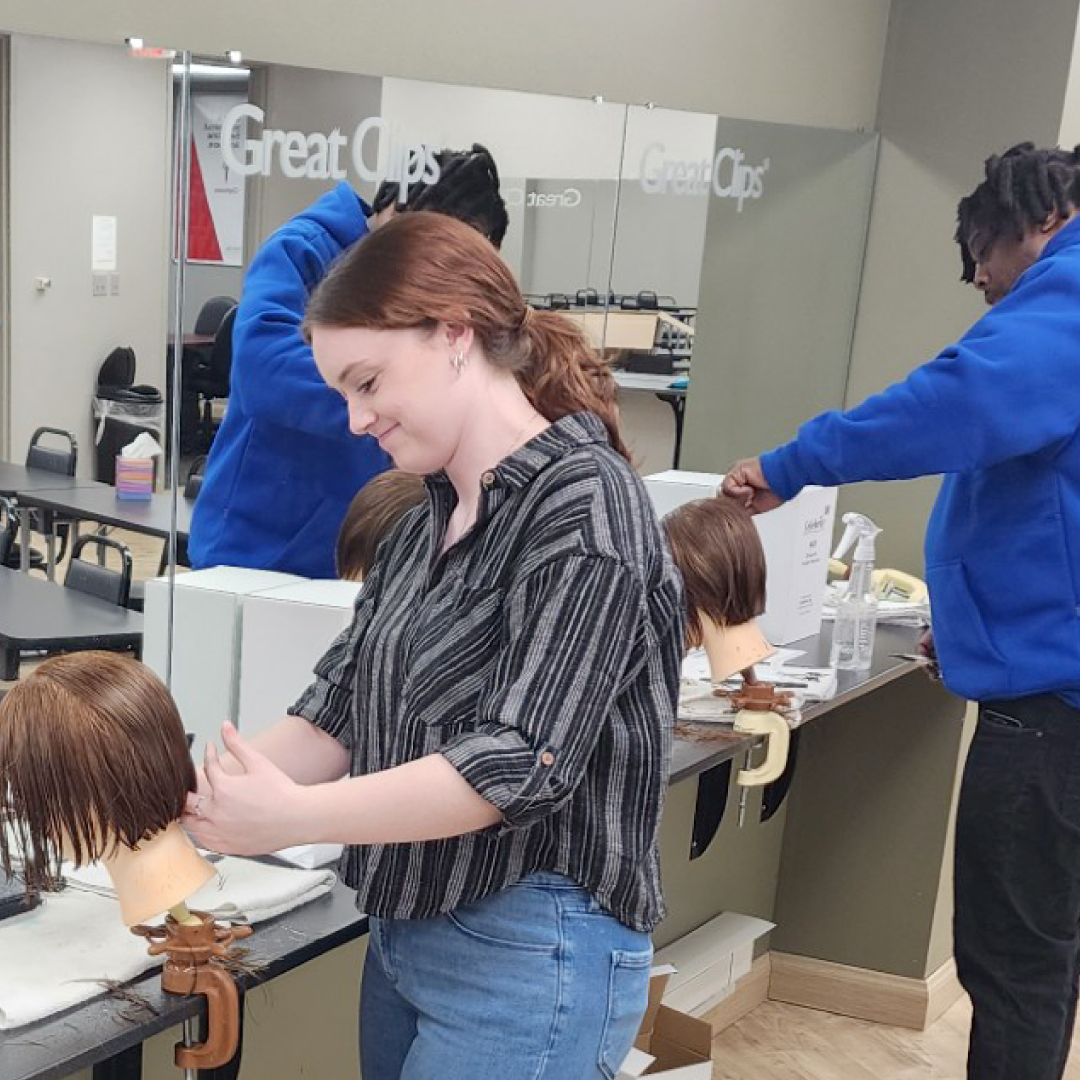 New stylists practice on mannequins in a training center
