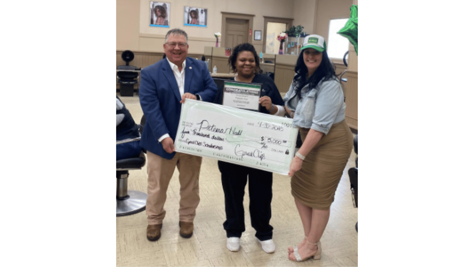 Smiling student holding giant scholarship check