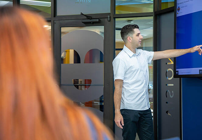 Image of person pointing towards screen
