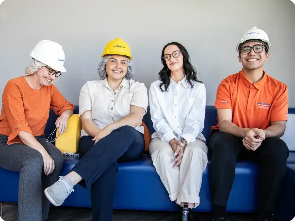 Employees are sitting on a couch and smiling