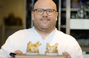 Man holding fries on platter