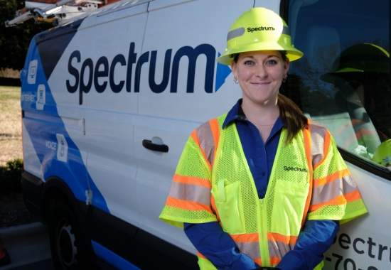 spectrum field technician employee standing in front of a spectrum van smiling at camera