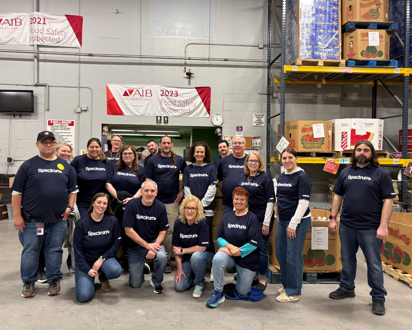volunteers in spectrum blue shirts pose in warehouse