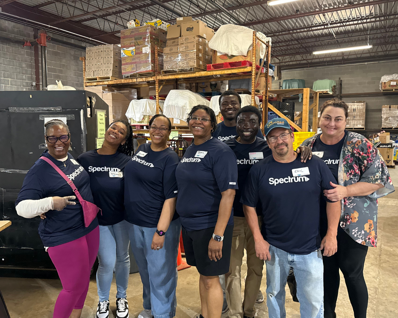 8 volunteers pose in warehouse in Raleigh