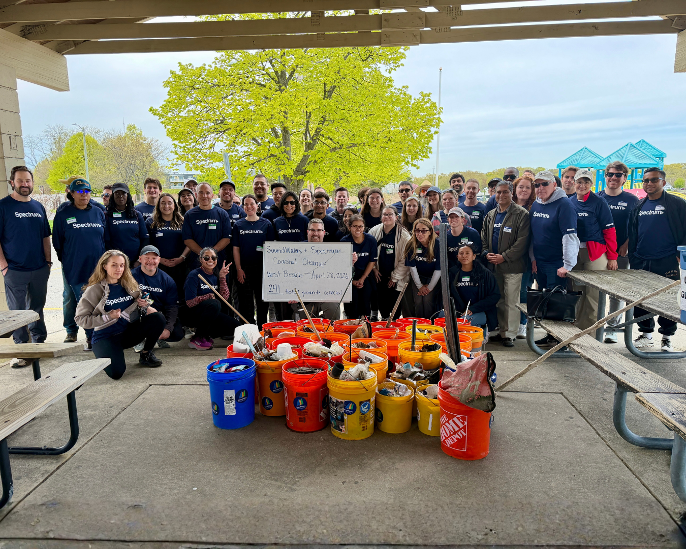 dozens of volunteers post at West Beach in Stamford in front of coastal refuse buckets