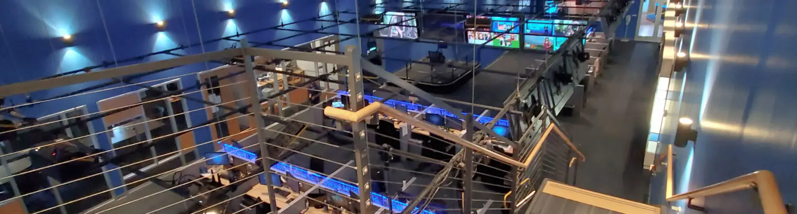 inside view of spectrum office space with desks, computers and tvs