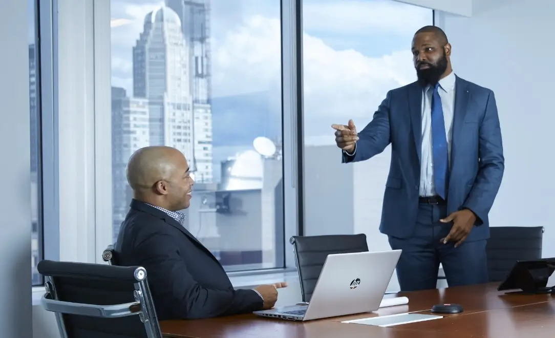 two spectrum employees talking in a conference room with a city skyline behind them