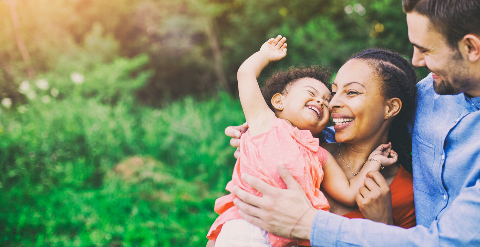 happy multi-racial couple with a toddler in their arms