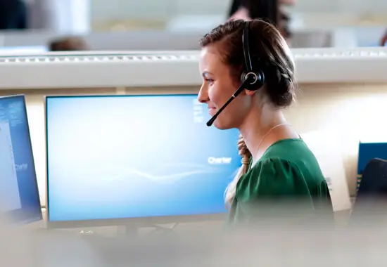 spectrum inside sales call center employee wearing a headset sitting at desk in front of a computer