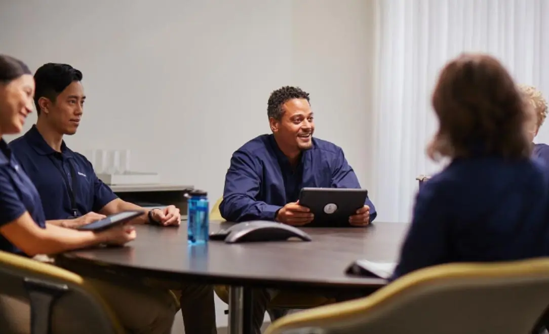 group of Spectrum employees sitting at a round table talking