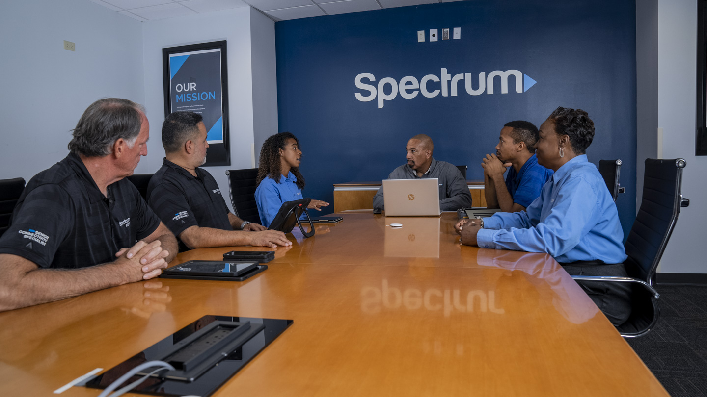 Group of employees in business casual attire in a Spectrum conference room