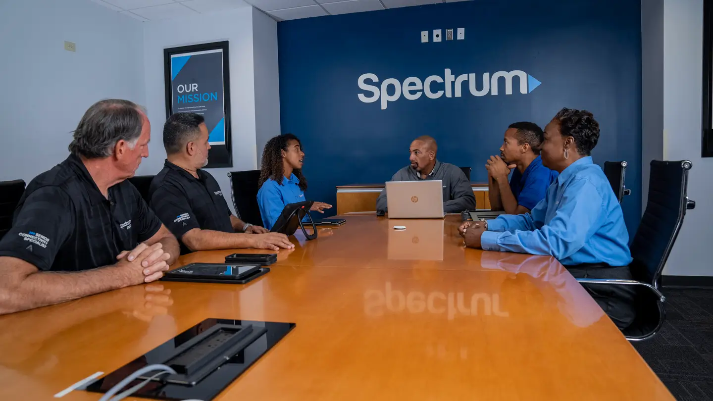 Group of employees in business casual attire in a Spectrum conference room