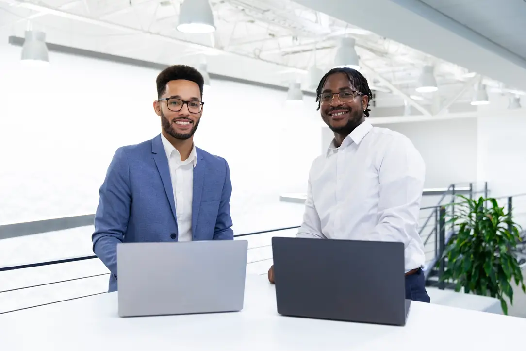 two spectrum employees with laptops smiling at camera