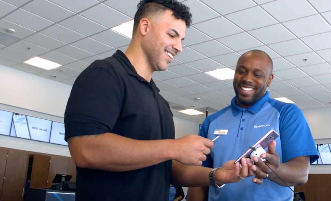 Store employee showing a male customer a phone