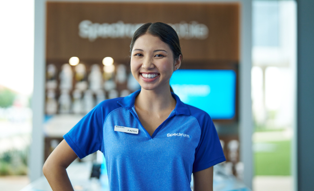 Female retail employee smiling in uniform for the camera