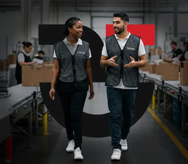 Two OnTrac employees walking down the assembly line