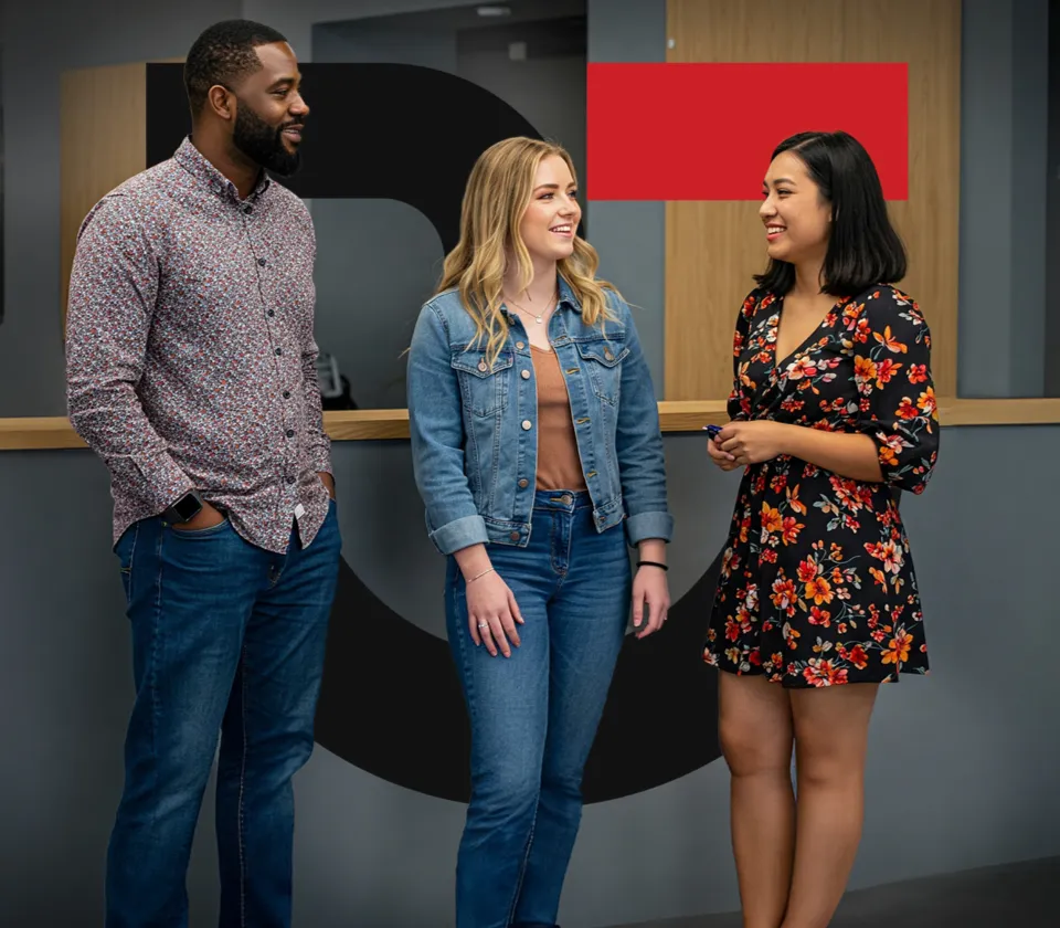 Three employees conversing in a hallways