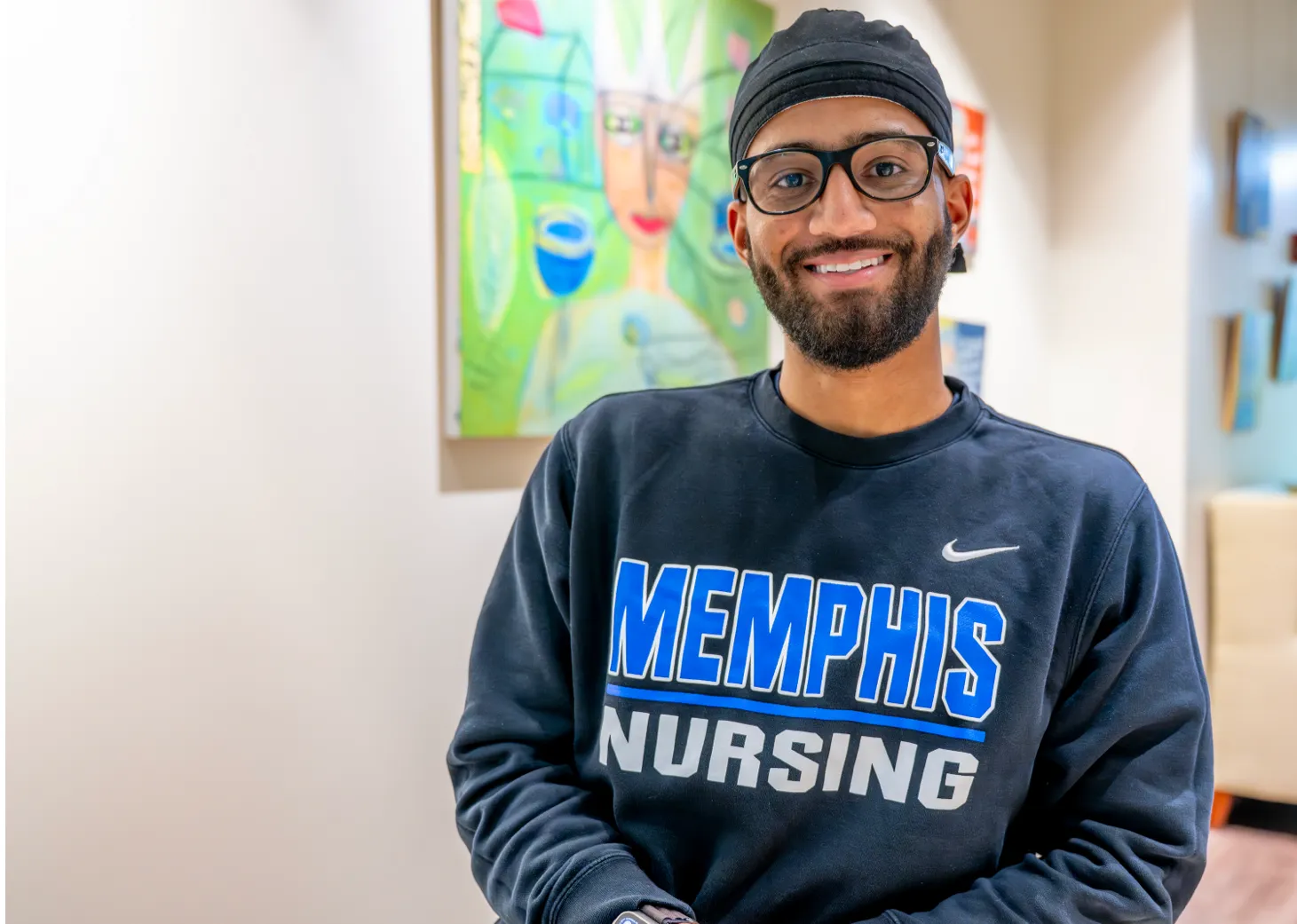 A new grad posing with his college diploma