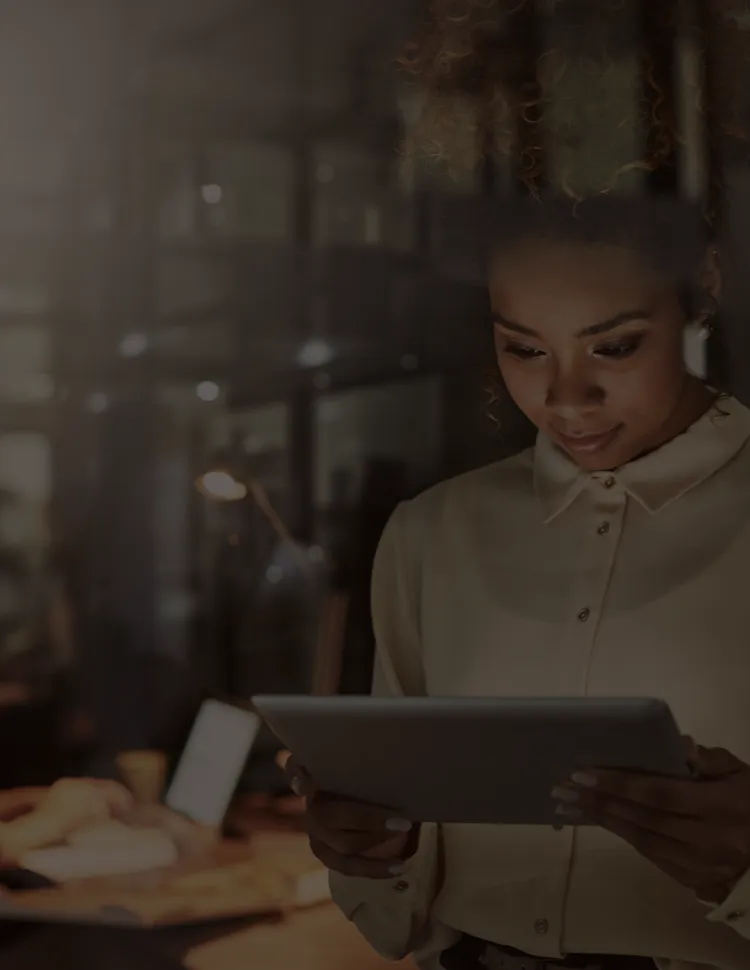 Woman in an office space reviewing something on a tablet