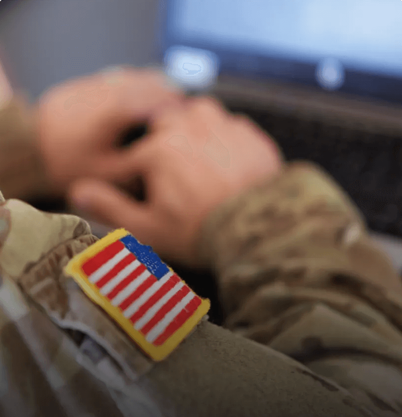 A man in military uniform on a laptop