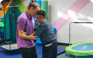 A person assists another person by holding their arms.