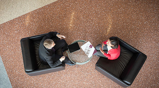 Man and woman sitting in chairs talking to each other