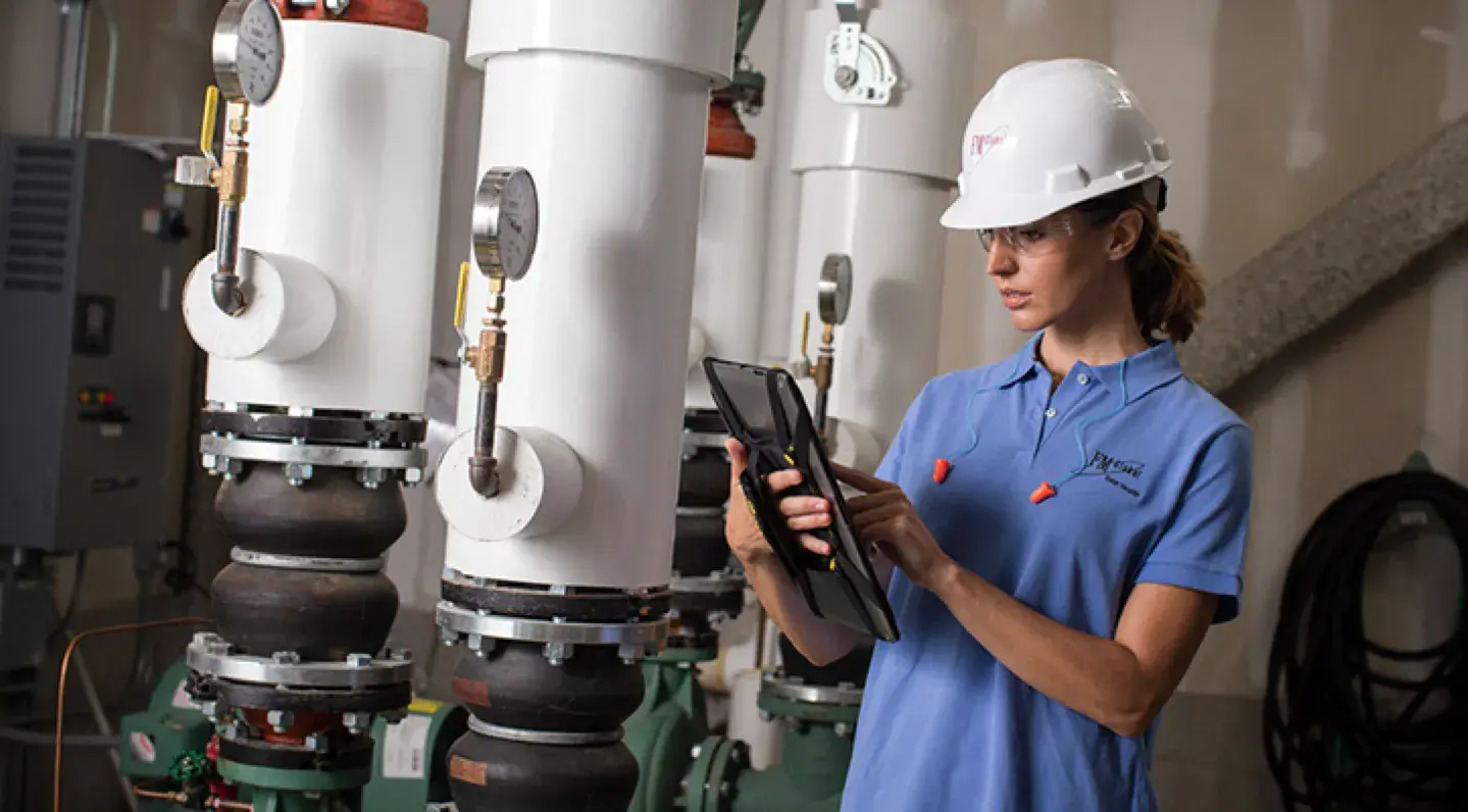 Female engineer inspecting machine using iPad technology