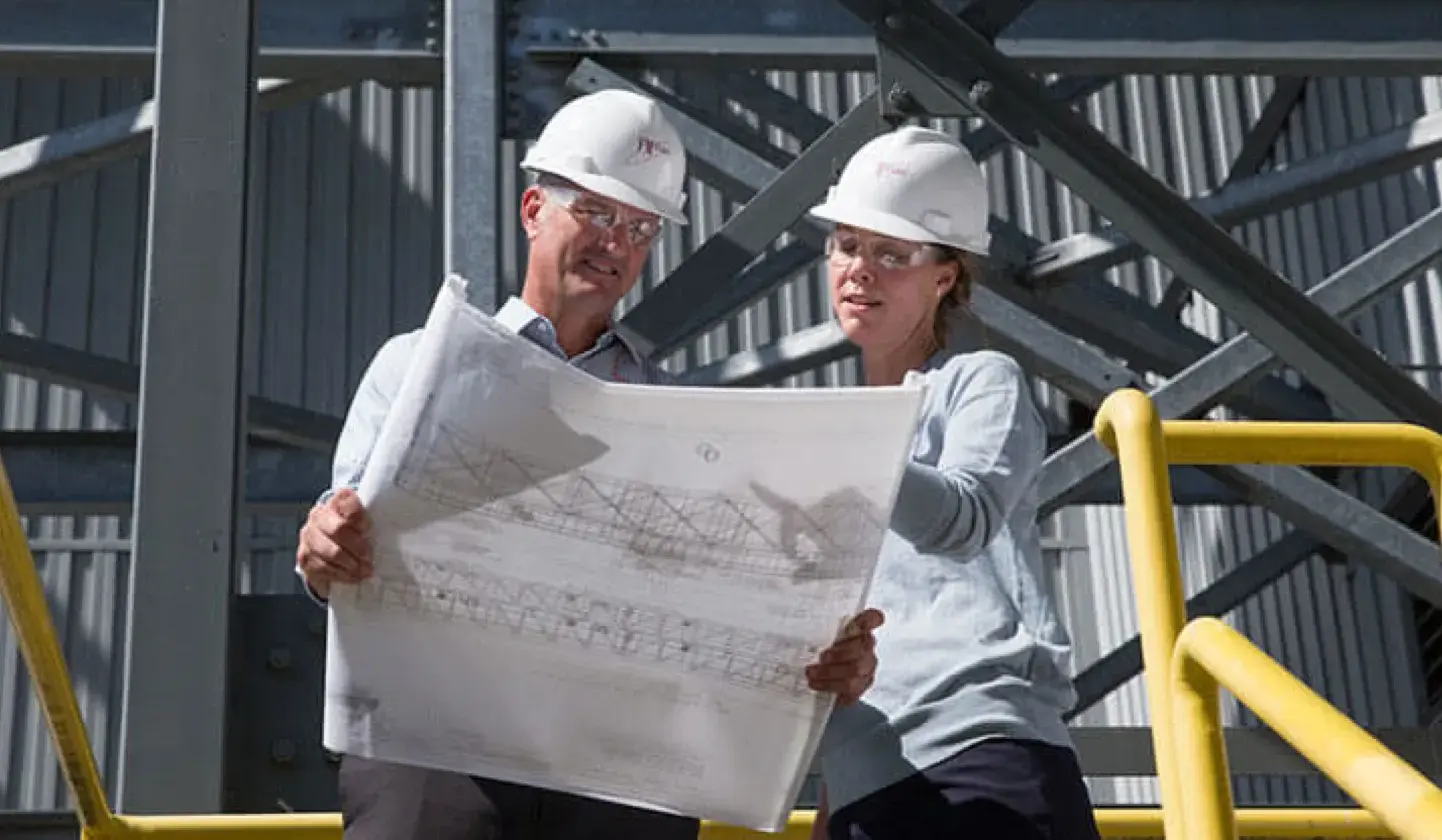 Male and female engineer looking at plans