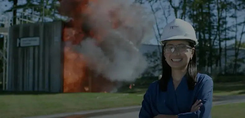 Female engineer smiling in front of burning structure