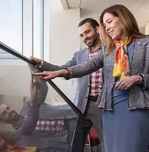 Two employees looking at large computer screen