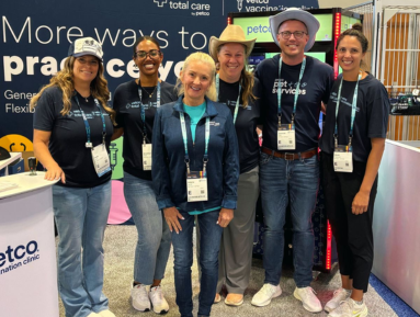 Vetco Total Care and Petco partners smiling together at a veterinary conference booth.